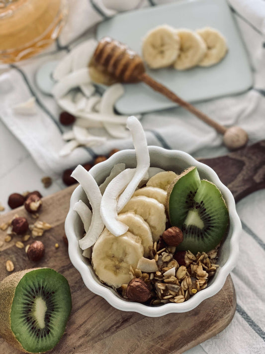 granola z orzechami i miodem na desce do krojenia z płatkami kokosowymi